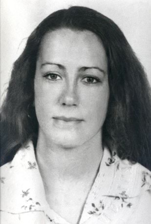 Julie Garciacelay, with long hair, and wearing a while collared shirt with a flower pattern.