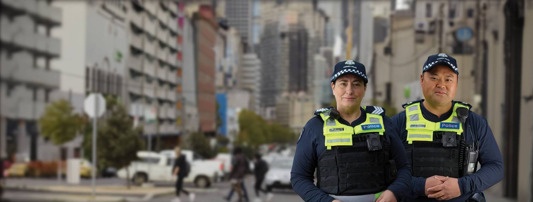 A female and a male uniformed Victoria police officers with a blurred city background A female and a male uniformed Victoria police officers with a blurred city background