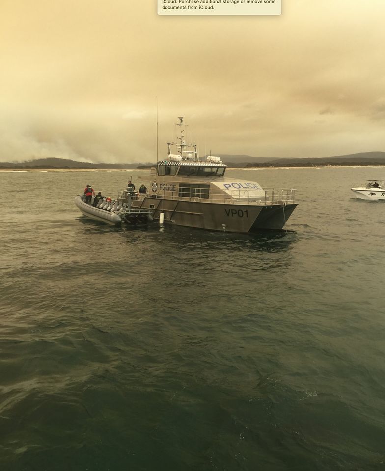 Victorian bushfires 2019-2020 - Police boats on the water with smoky sky