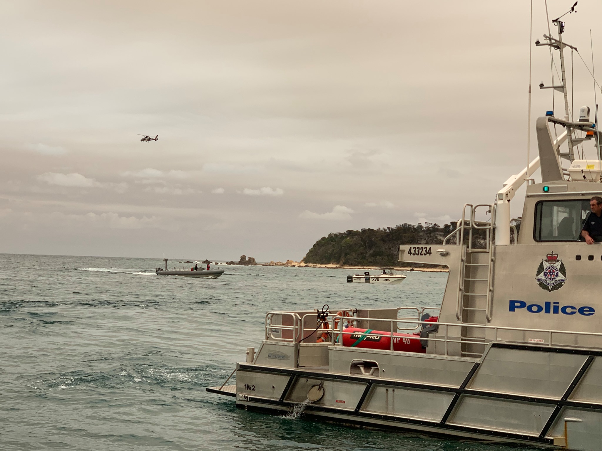 Victorian bushfires 2019-2020 - Police boats on the water with helicopter above