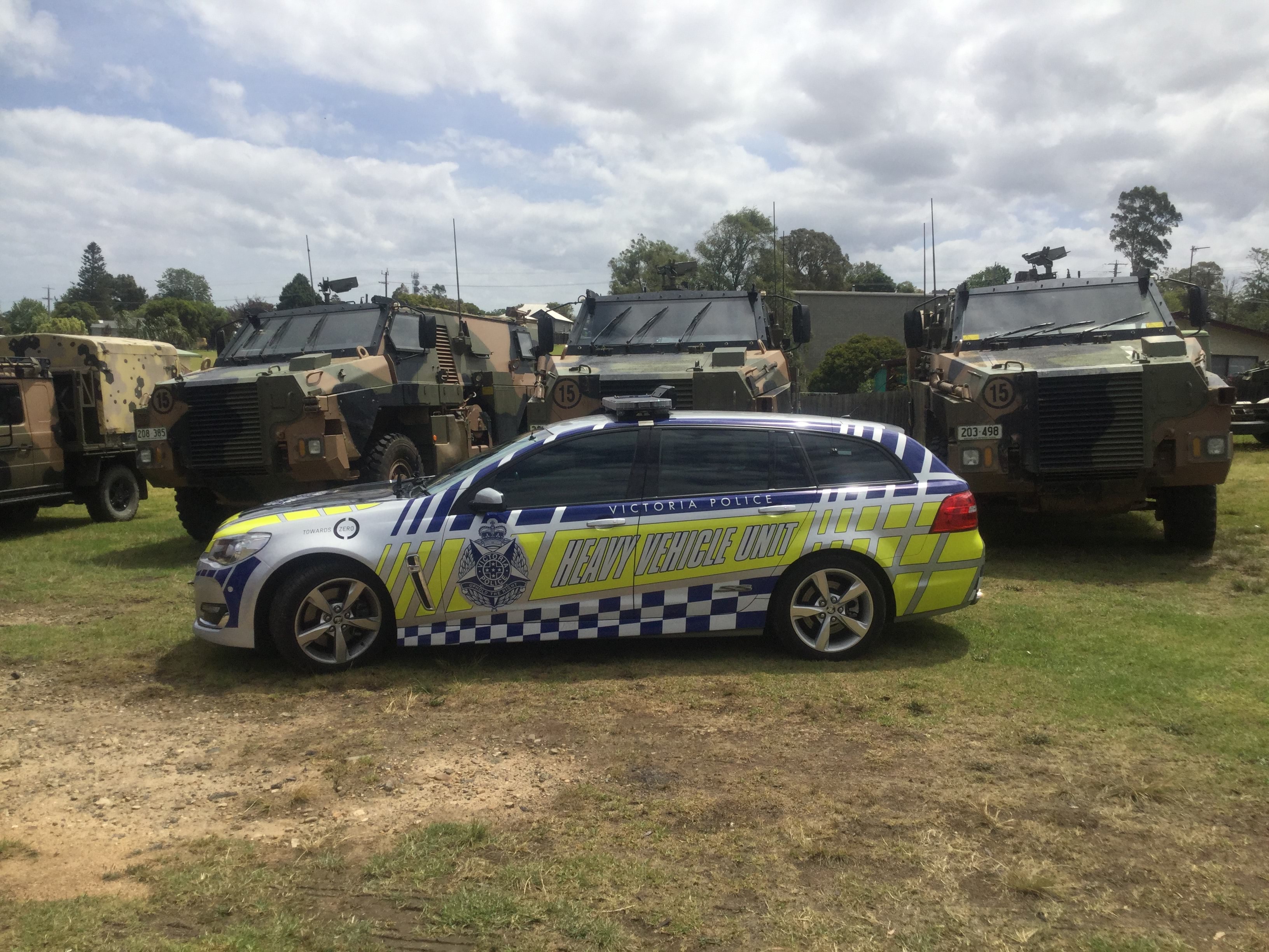 Victorian bushfires 2019-2020 - Heavy vehicle unit car alongside multiple army vehicles parked on grass