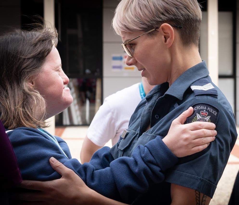 Disability Liaison Officer embracing a member of the public.