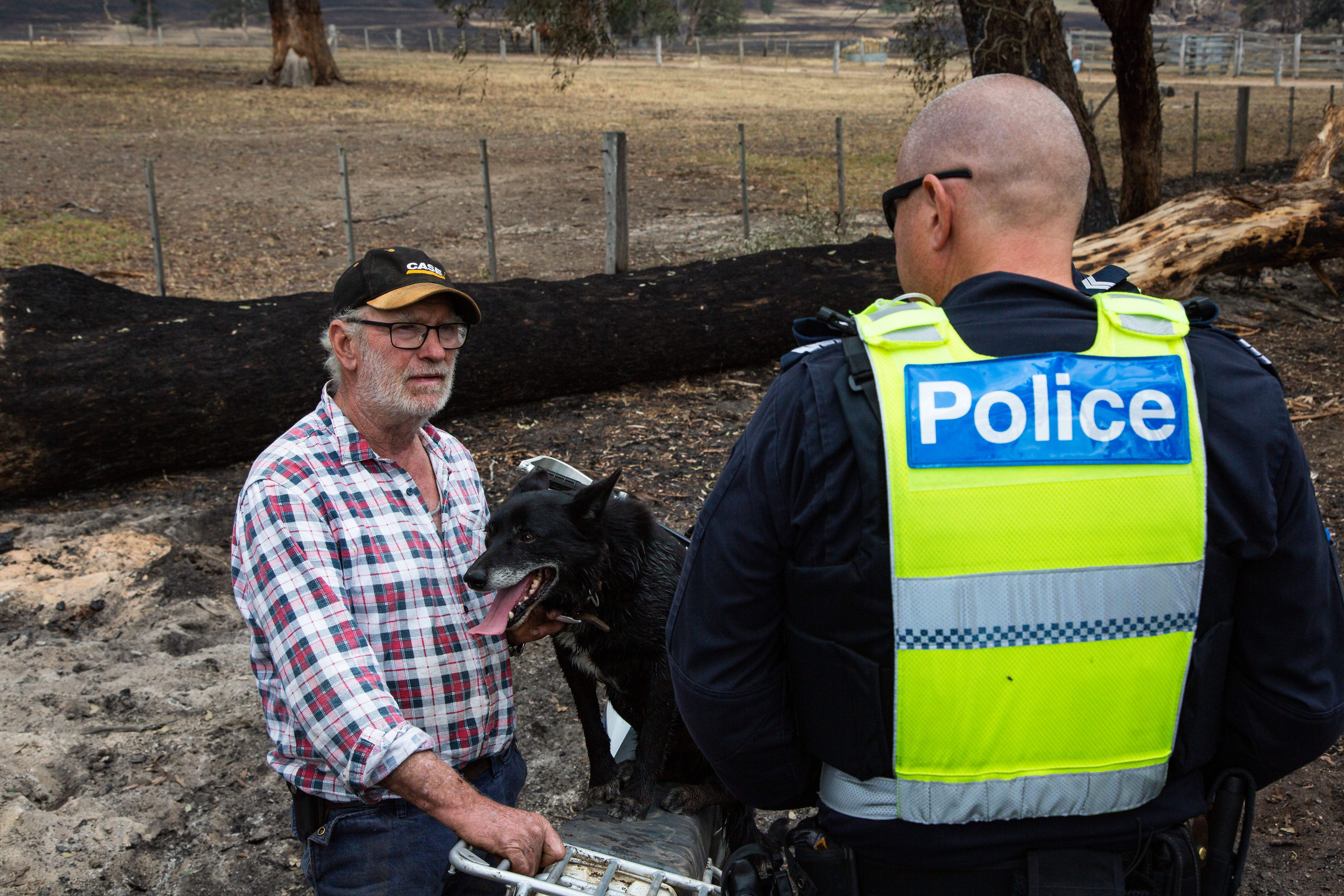 Victorian bushfires 2019-2020 - Police officer talking to a community member by a fence