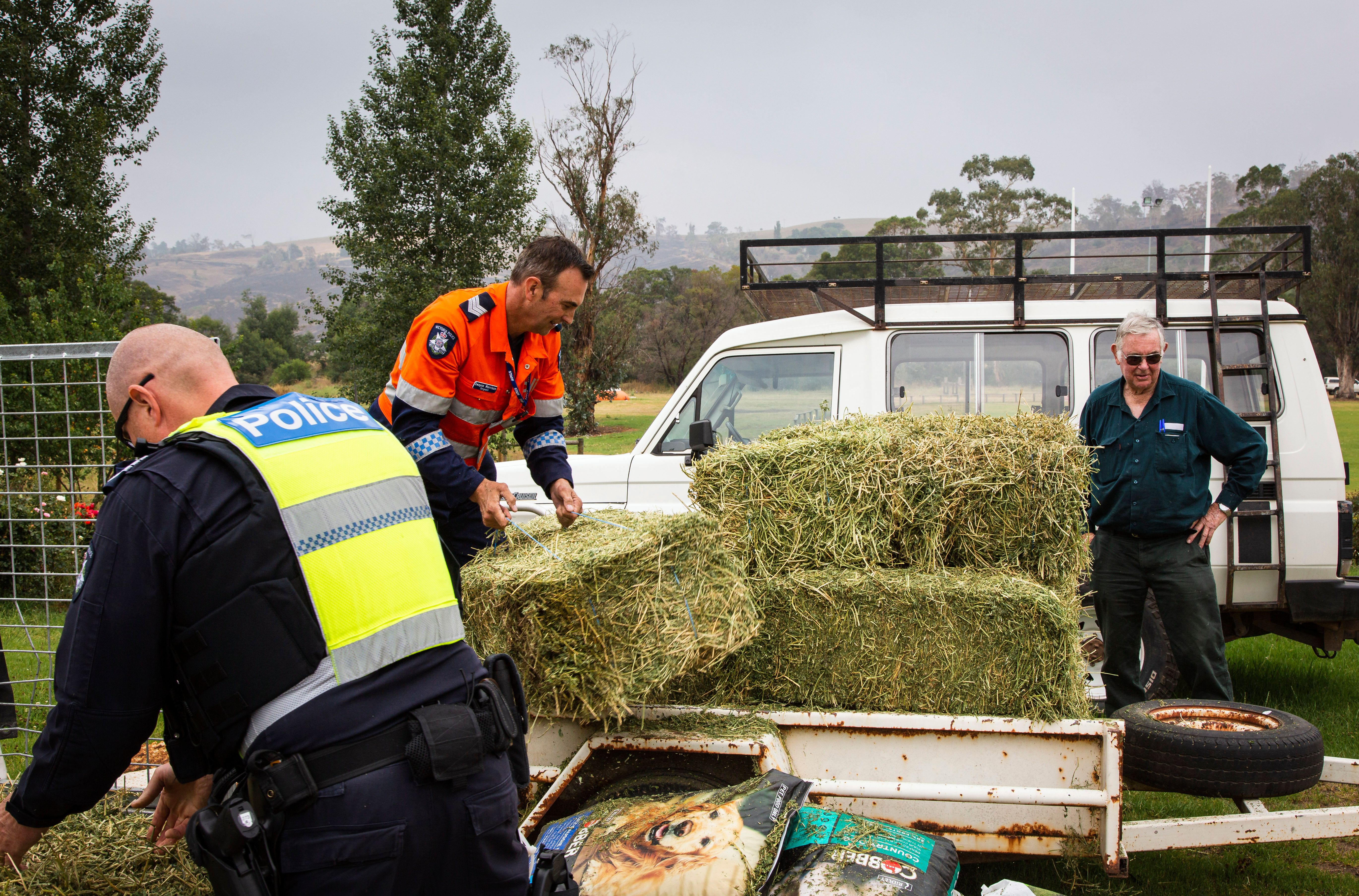 Victorian bushfires 2019-2020 - Two police officers loading hay onto a trailer