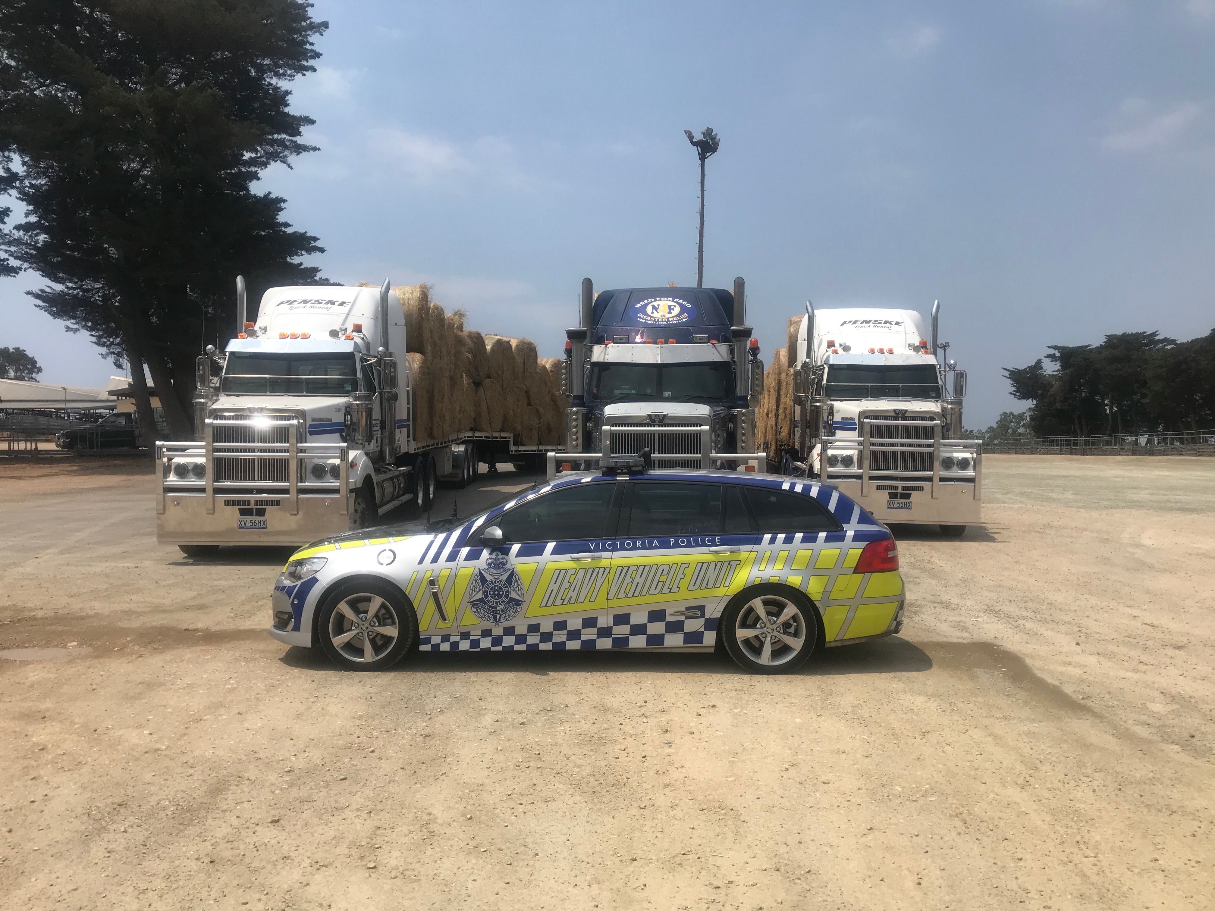 Victorian bushfires 2019-2020 - Police car parked in front of three big hay trucks