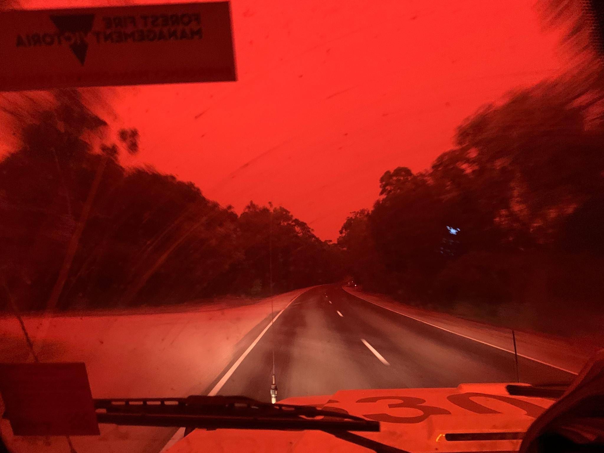 Victorian bushfires 2019-2020 - Bright red sky and road seen from a moving police car