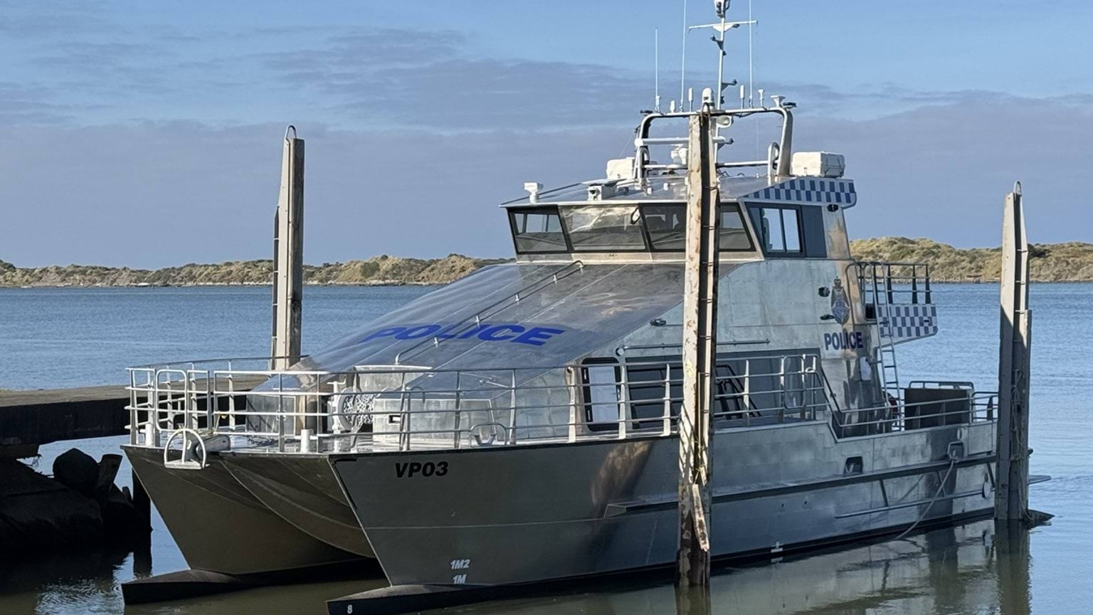 Police Life - silver police boat moored at jetty.