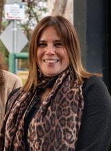 Jacqui Marion is smiling and looking directly at the camera. She is standing outside wearing a leopard print scarf and a black, long-sleeved top.